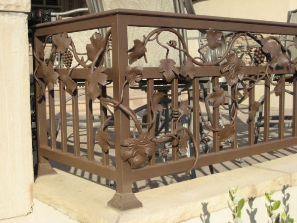 A wrought iron railing with grapes and leaves on it