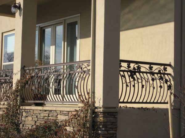 A balcony with a wrought iron railing and sliding glass doors