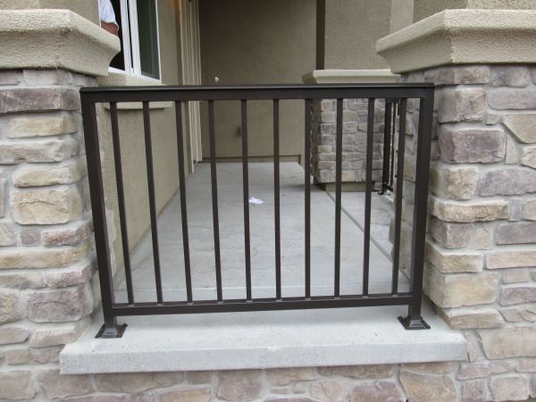 A brick wall with a metal railing on it