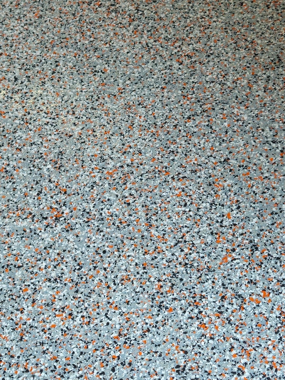 Close-up of a speckled gray, blue, and orange textured surface