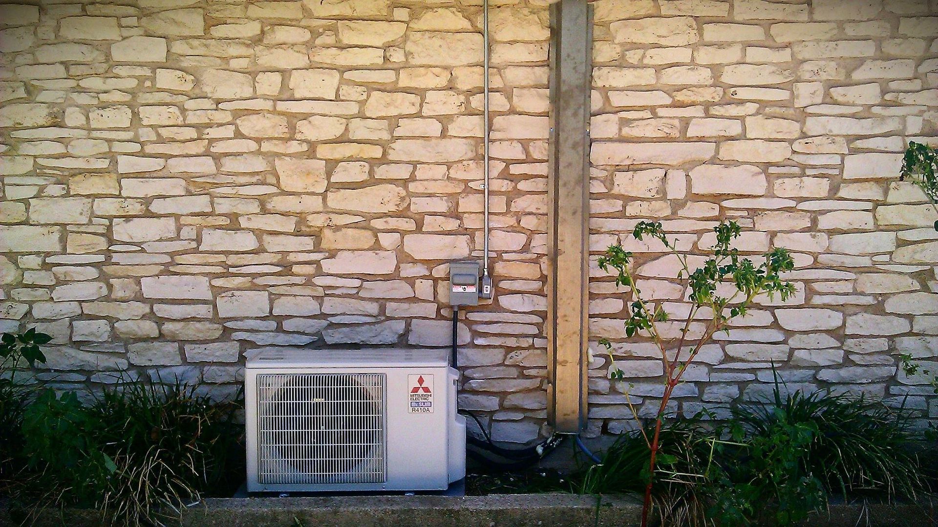 A brick wall with an air conditioner on it