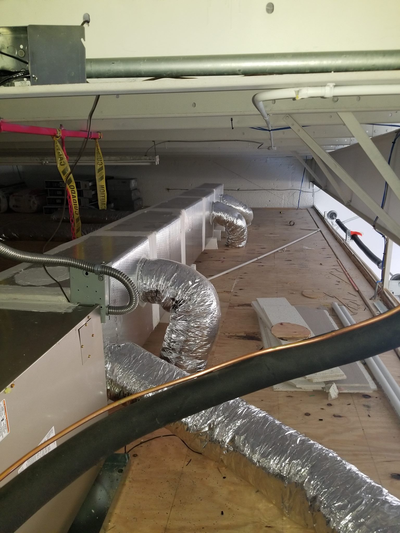 A room with a lot of pipes and ducts coming out of the ceiling.