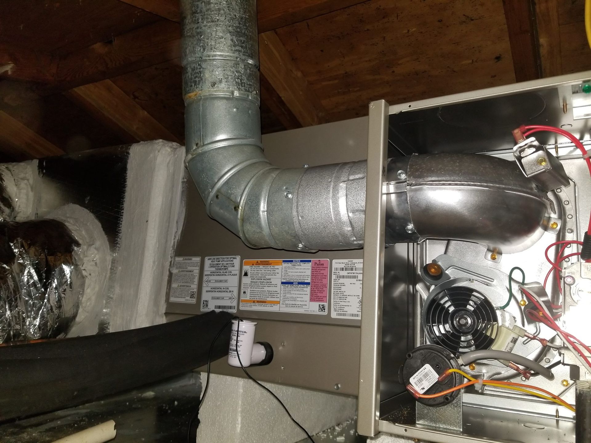 A close up of a furnace with a hose coming out of it.