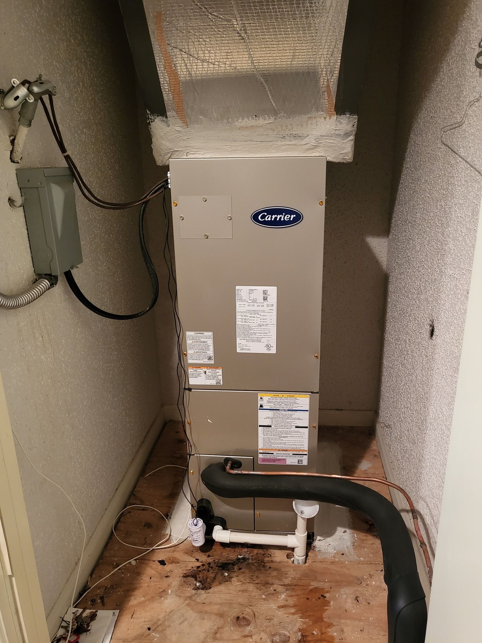 An air conditioner is sitting in a corner of a room.