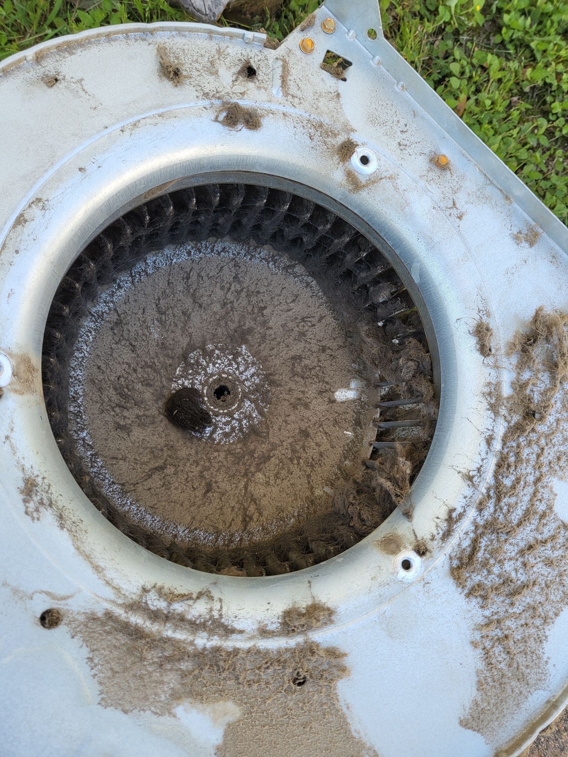 A close-up of a dirty blower with a hole in the middle