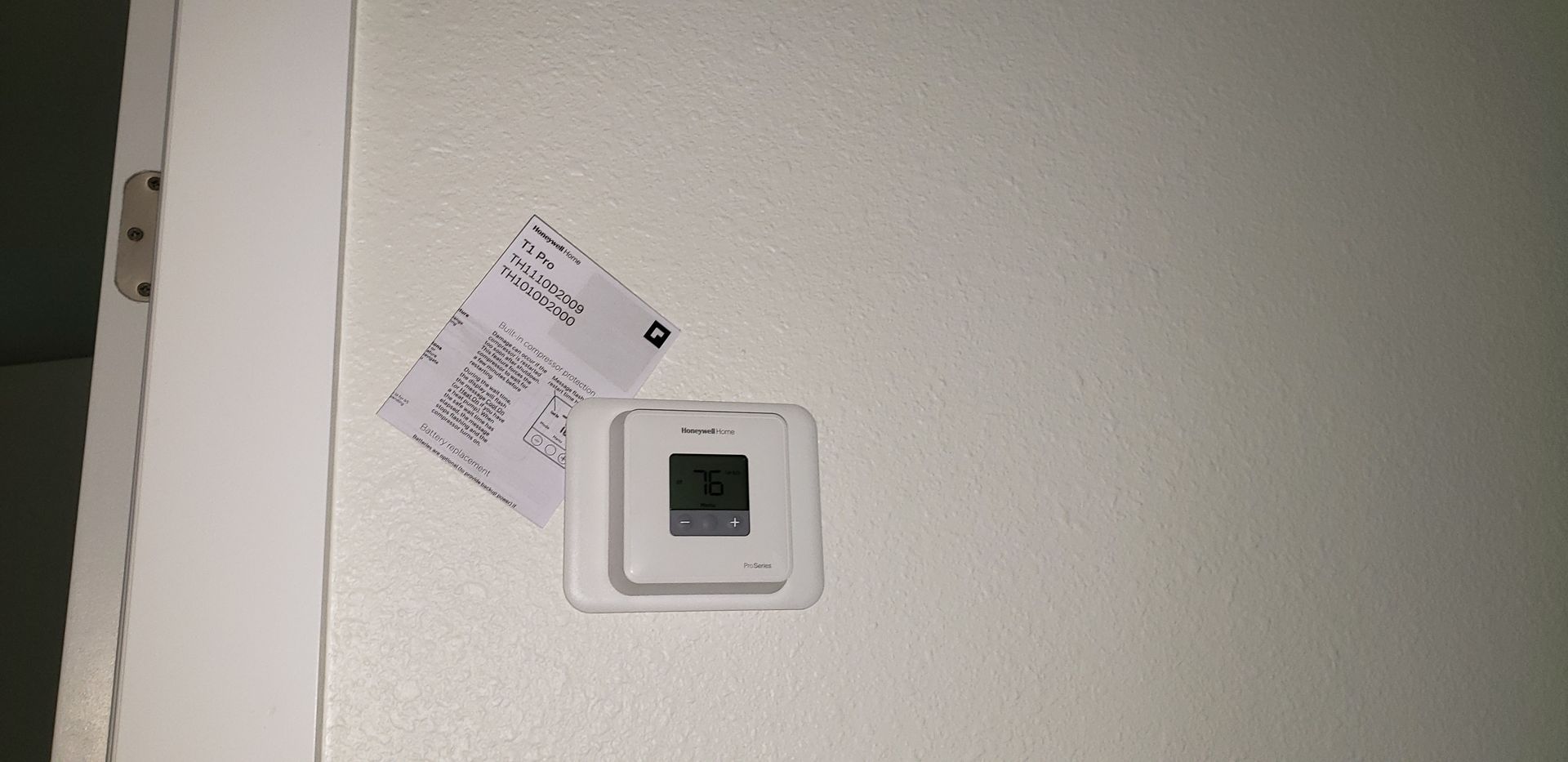A receipt is taped to a wall next to a thermostat