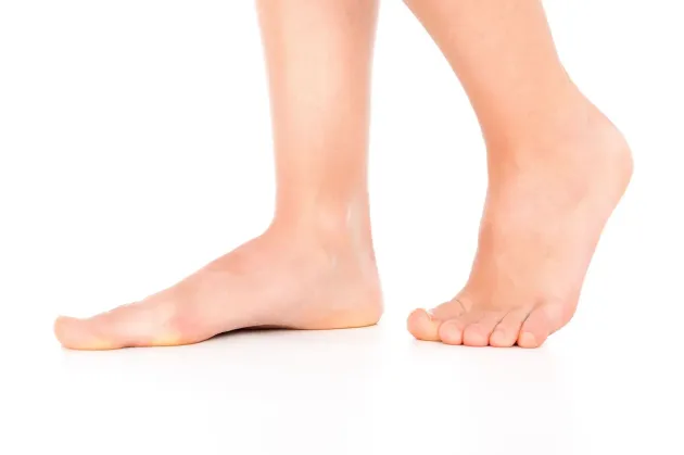 Close-up of bare feet and lower legs walking on a white background