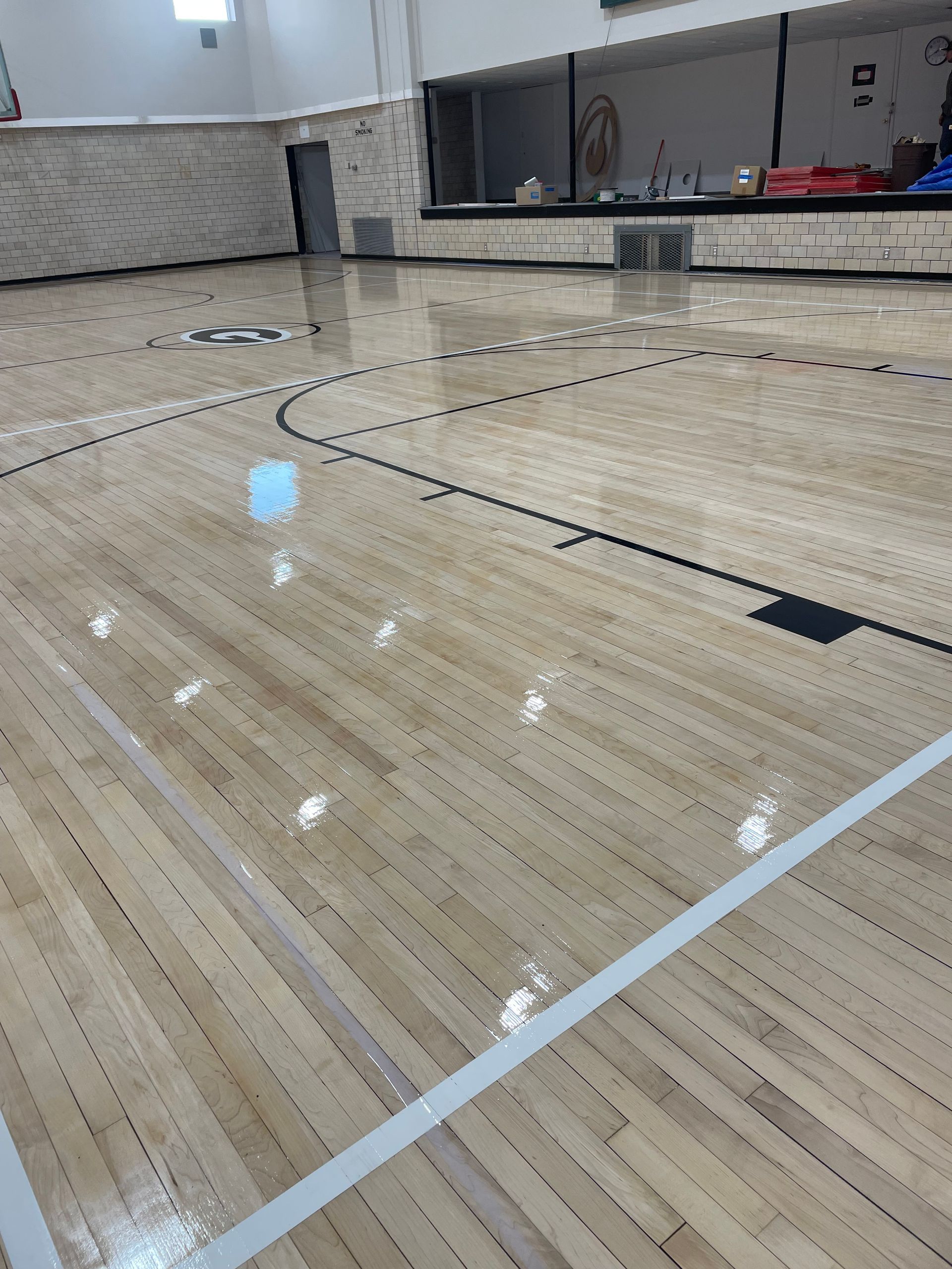 A basketball court with a wooden floor in a gym.