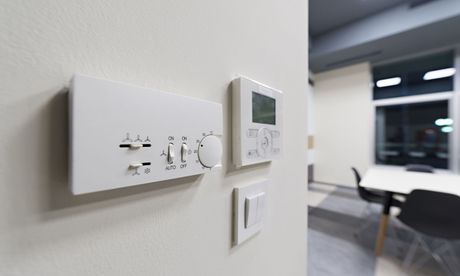 A close up of a thermostat on a wall in a room.