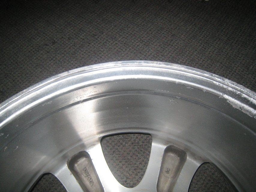 A close up of a silver rim on a black surface