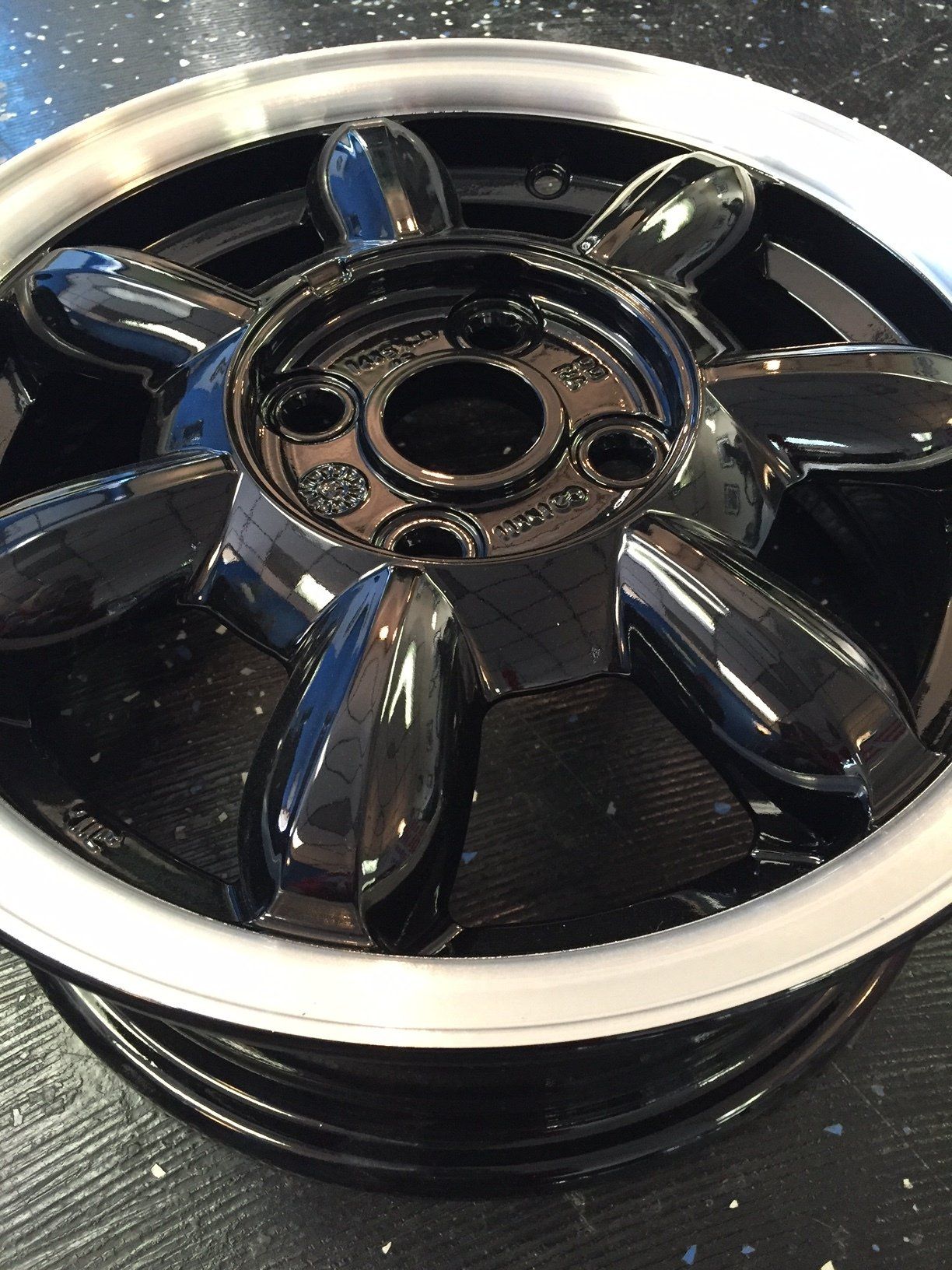A close up of a black wheel with a white rim