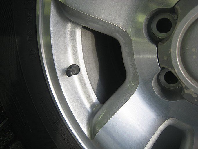 A close up of a tire valve on a car wheel