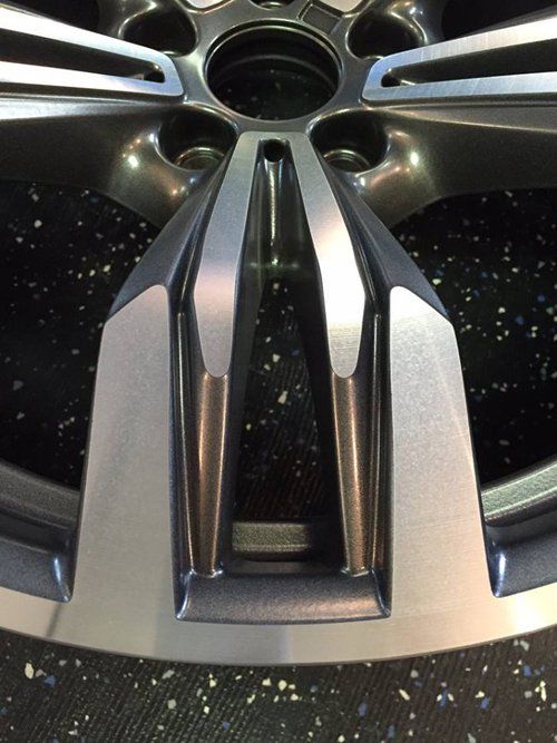 A close up of a car wheel on a black surface