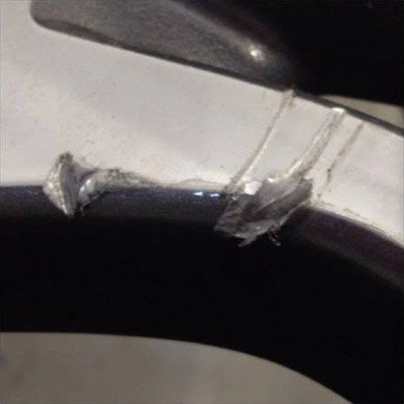 A close up of a broken piece of plastic on a toilet seat.