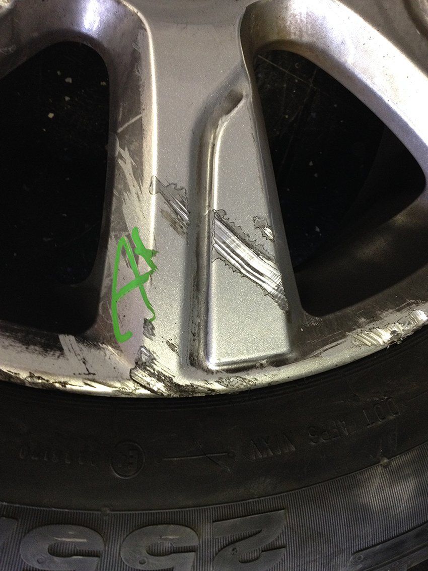 A close up of a car wheel with a green sticker on it.