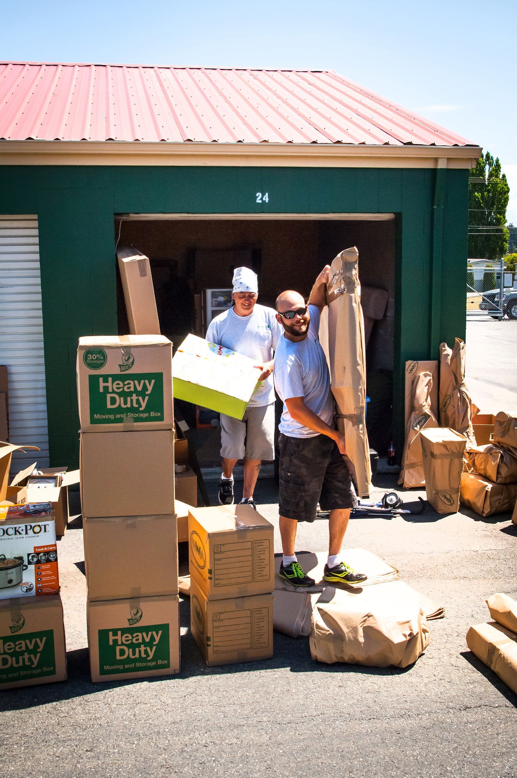 two men are standing in front of a garage full of heavy duty boxes .