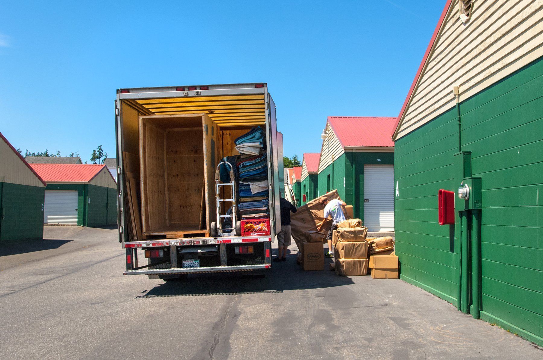 a truck is being loaded with boxes in a parking lot .