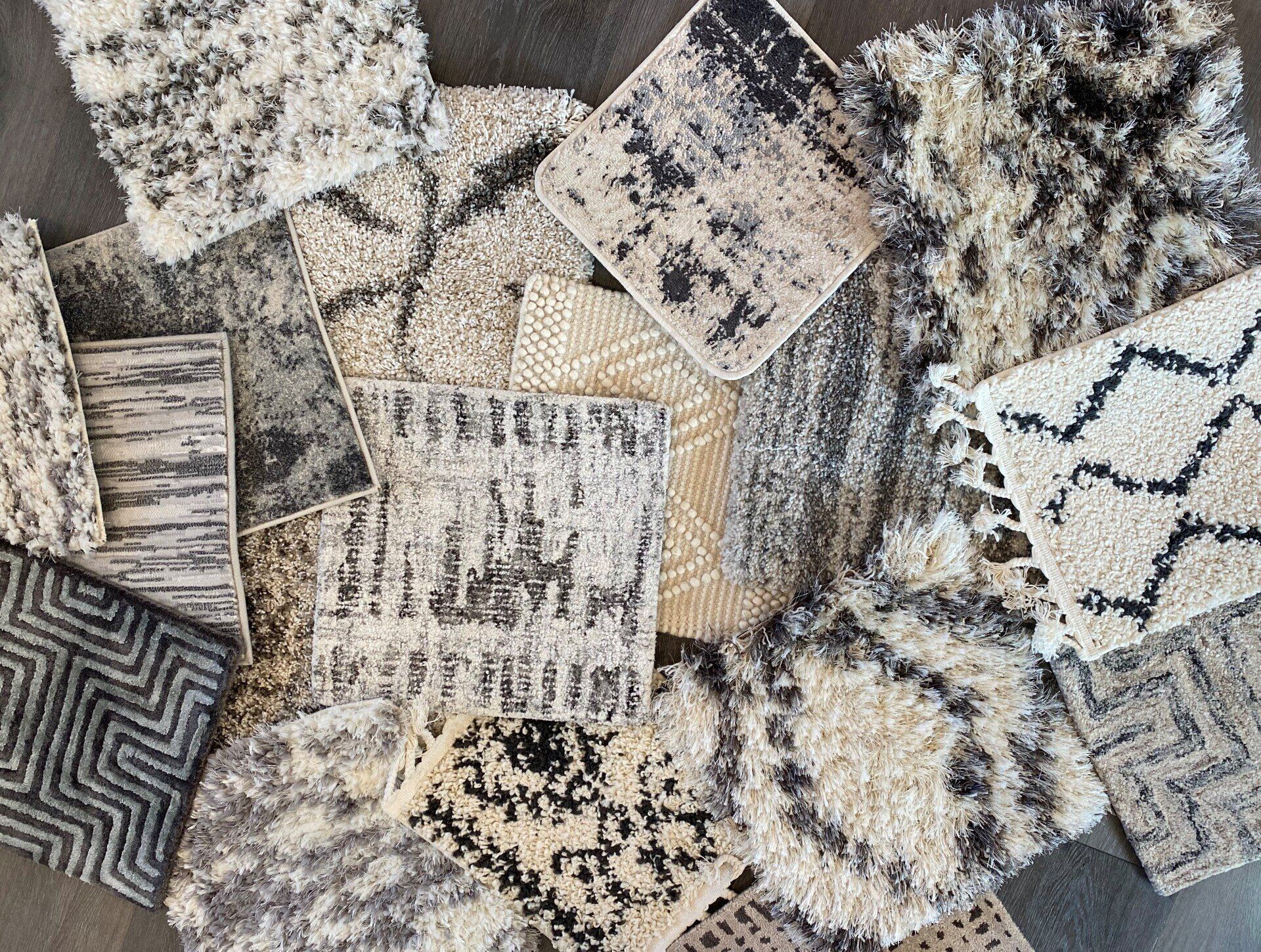 Assortment of neutral-toned rug samples featuring various patterns: geometric, abstract, and textured.