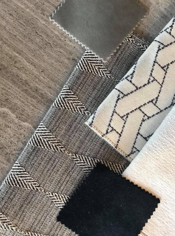 Assortment of gray fabric samples, including herringbone and geometric patterns.