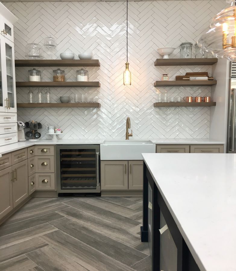 Kitchen with white herringbone tile backsplash, wooden shelves, and a wine fridge.