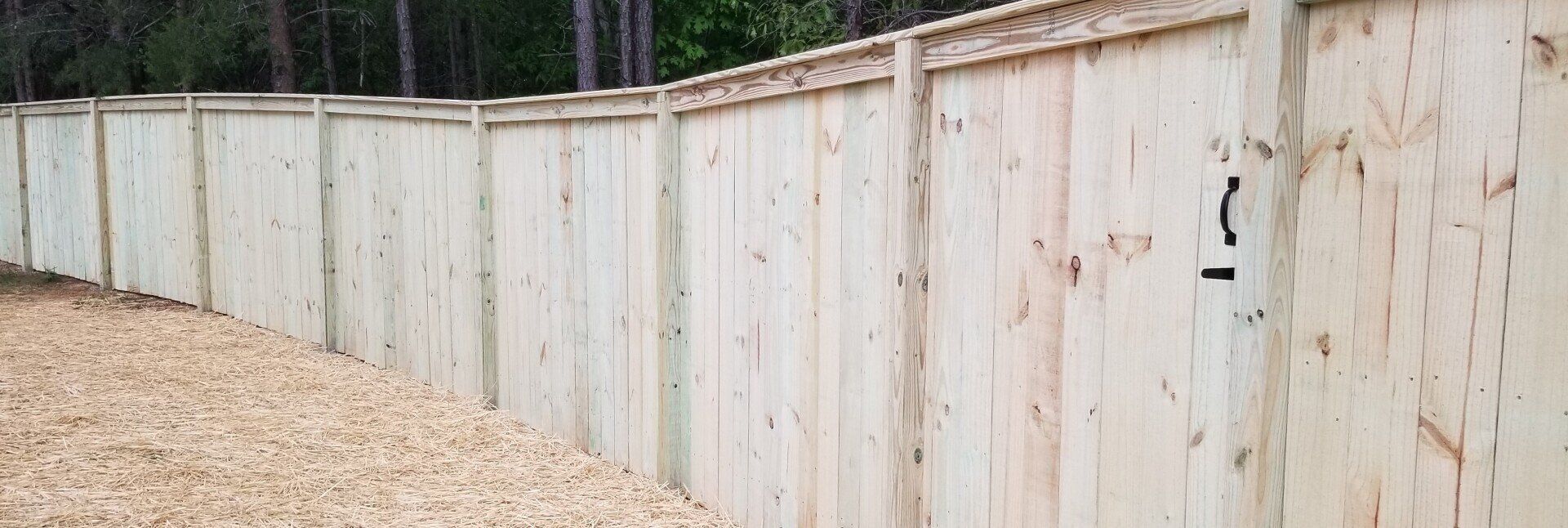 A wooden fence is sitting on top of a pile of wood chips.