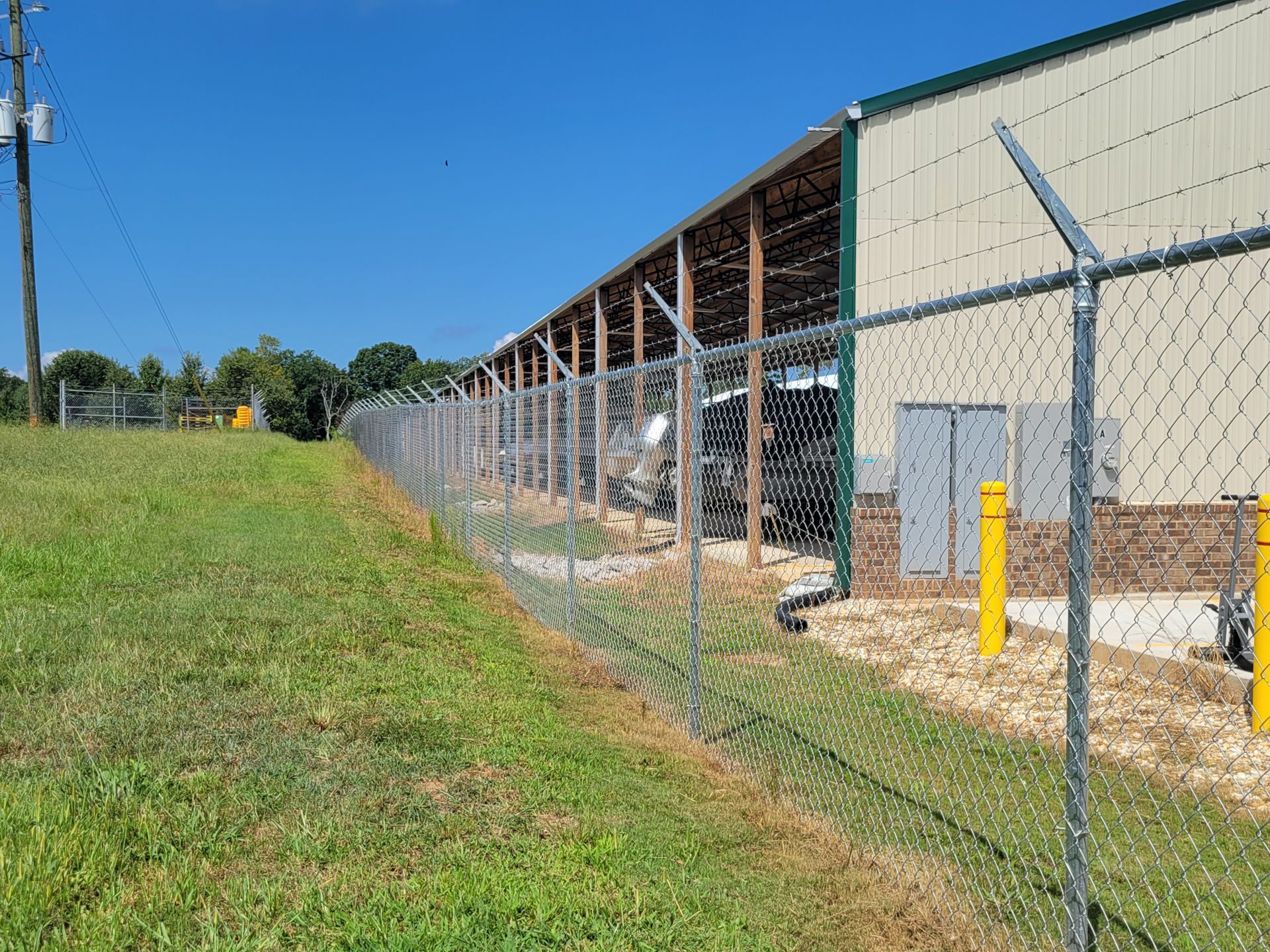 A chain link fence is surrounding a large building.