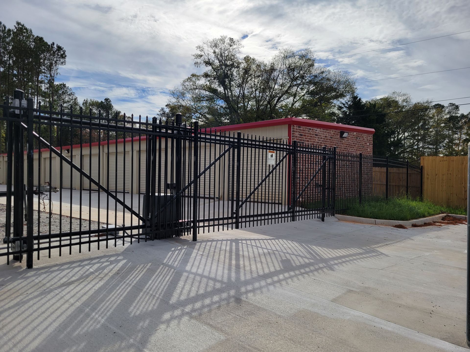 A black fence surrounds a building with a red roof