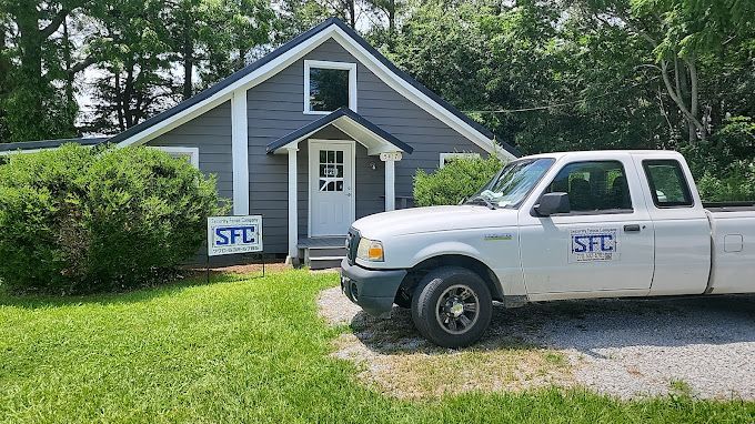 A white truck is parked in front of a house.