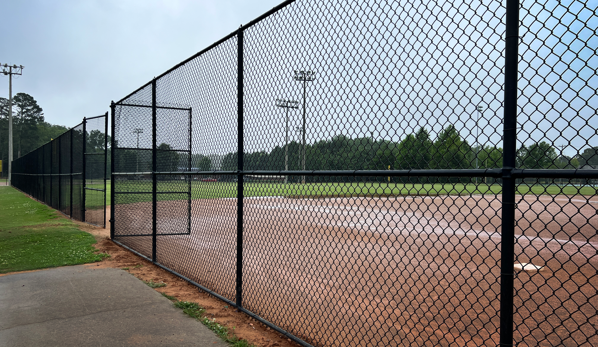 A chain link fence surrounds a baseball field.