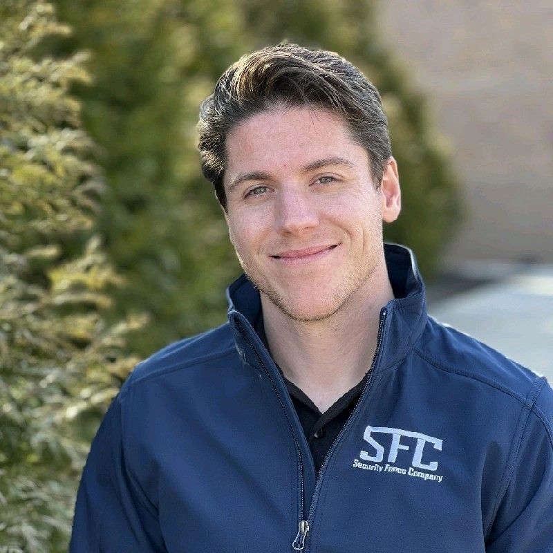 A man wearing a sfc jacket is smiling for the camera.
