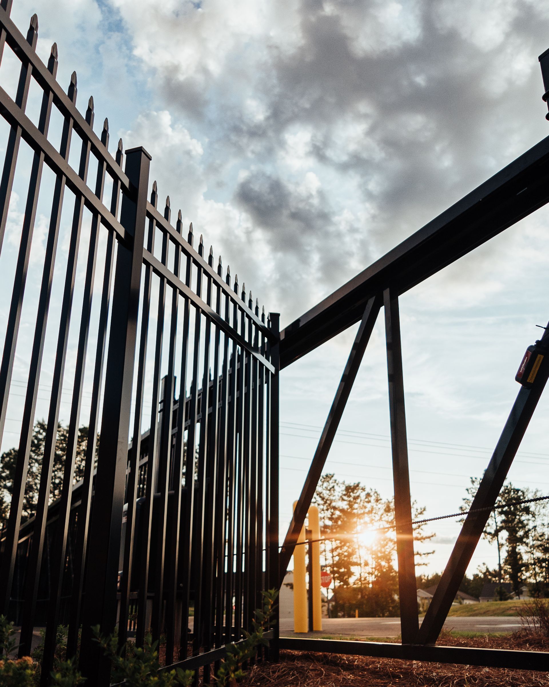 A black fence with a sliding gate in the background