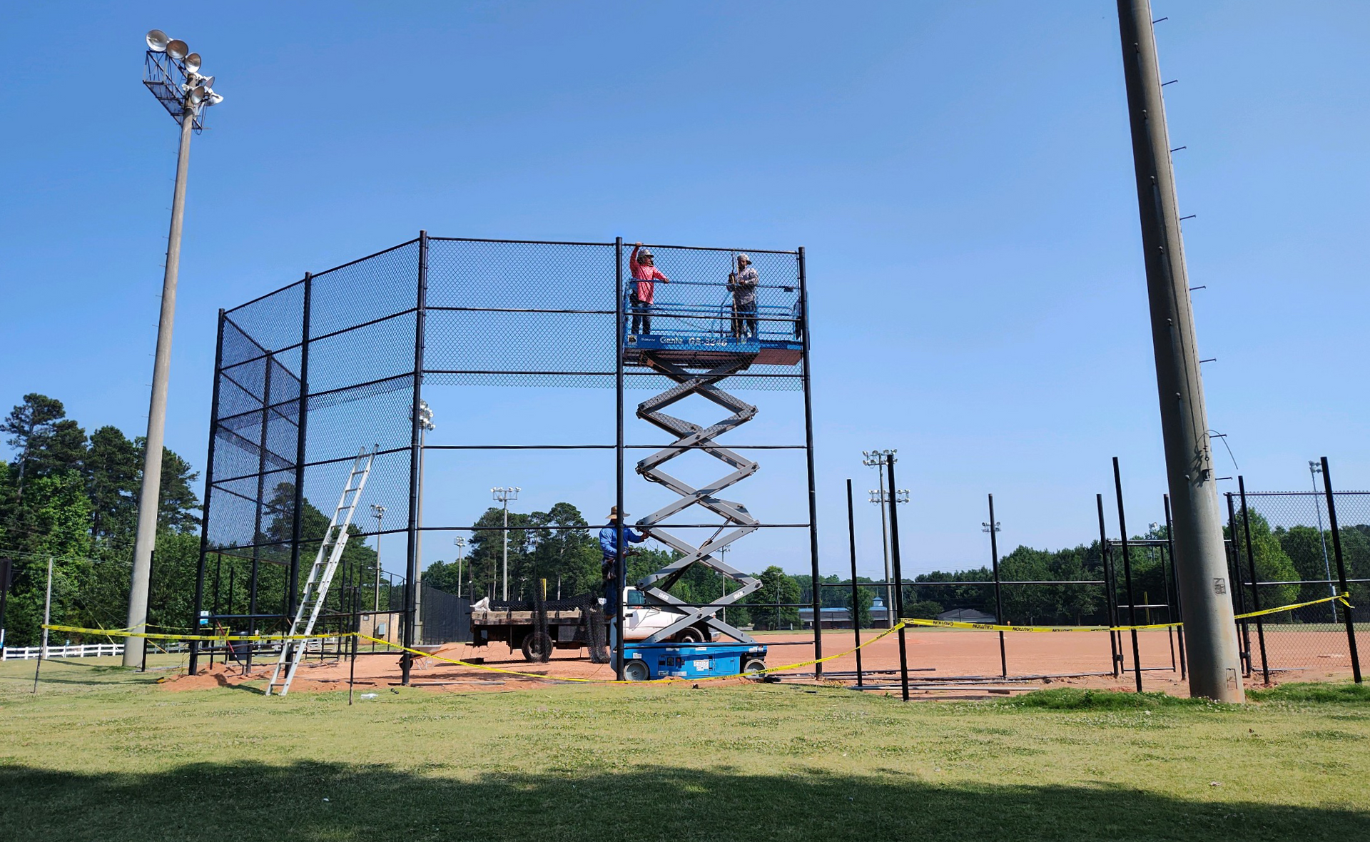 A baseball field is being built with a scissor lift.