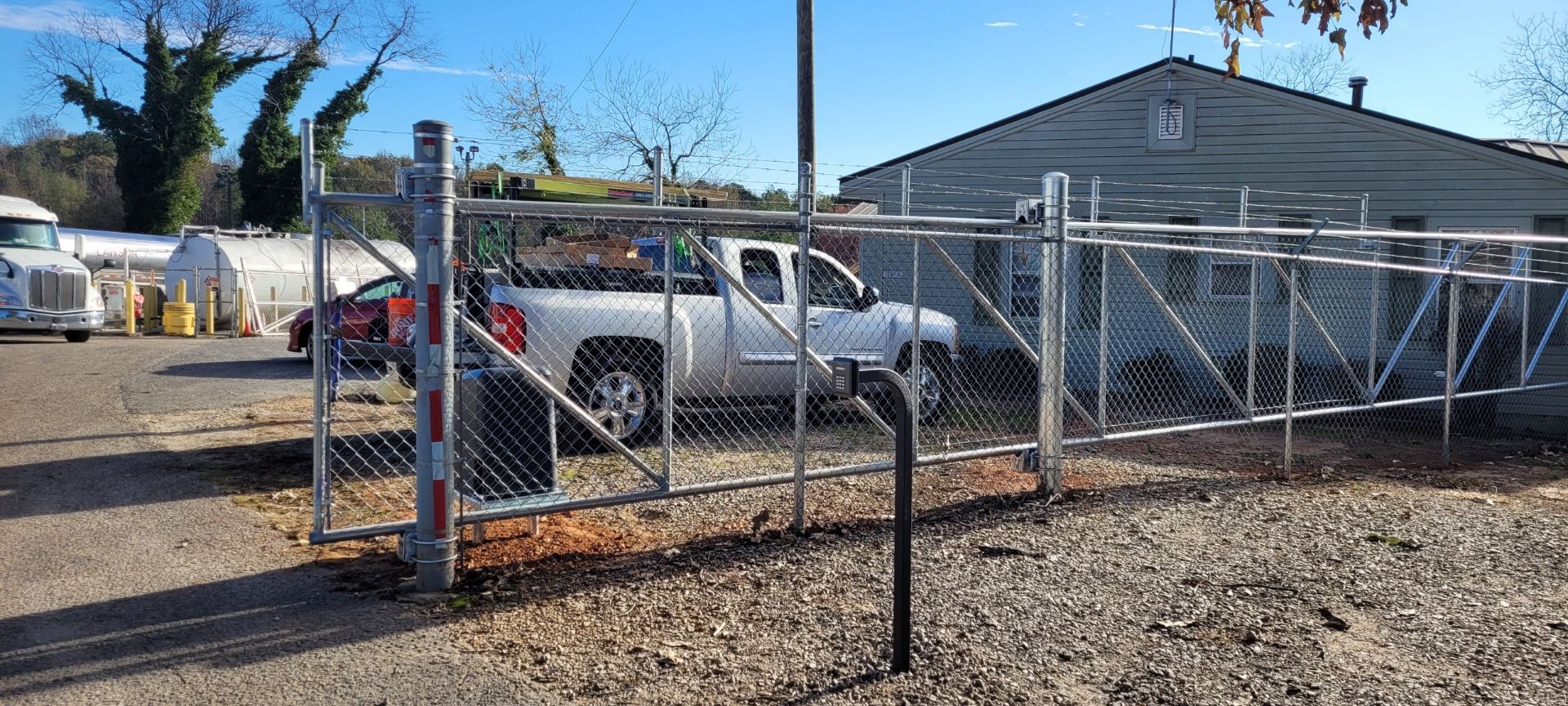 A chain link fence with a truck parked in front of it.