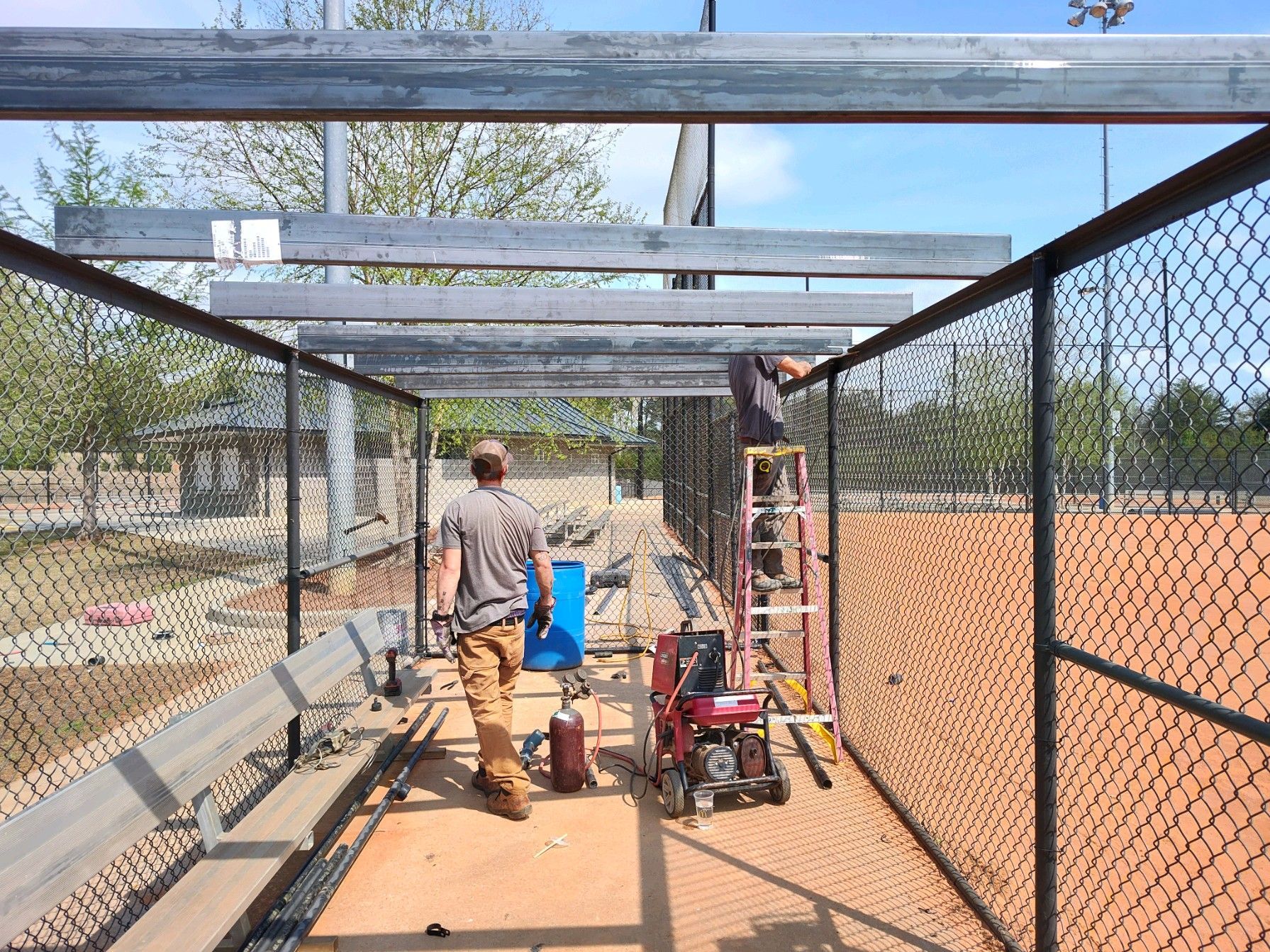 A group of men are working on a baseball field.