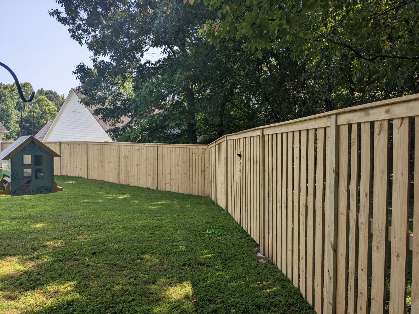 A wooden fence is being built in front of a house.