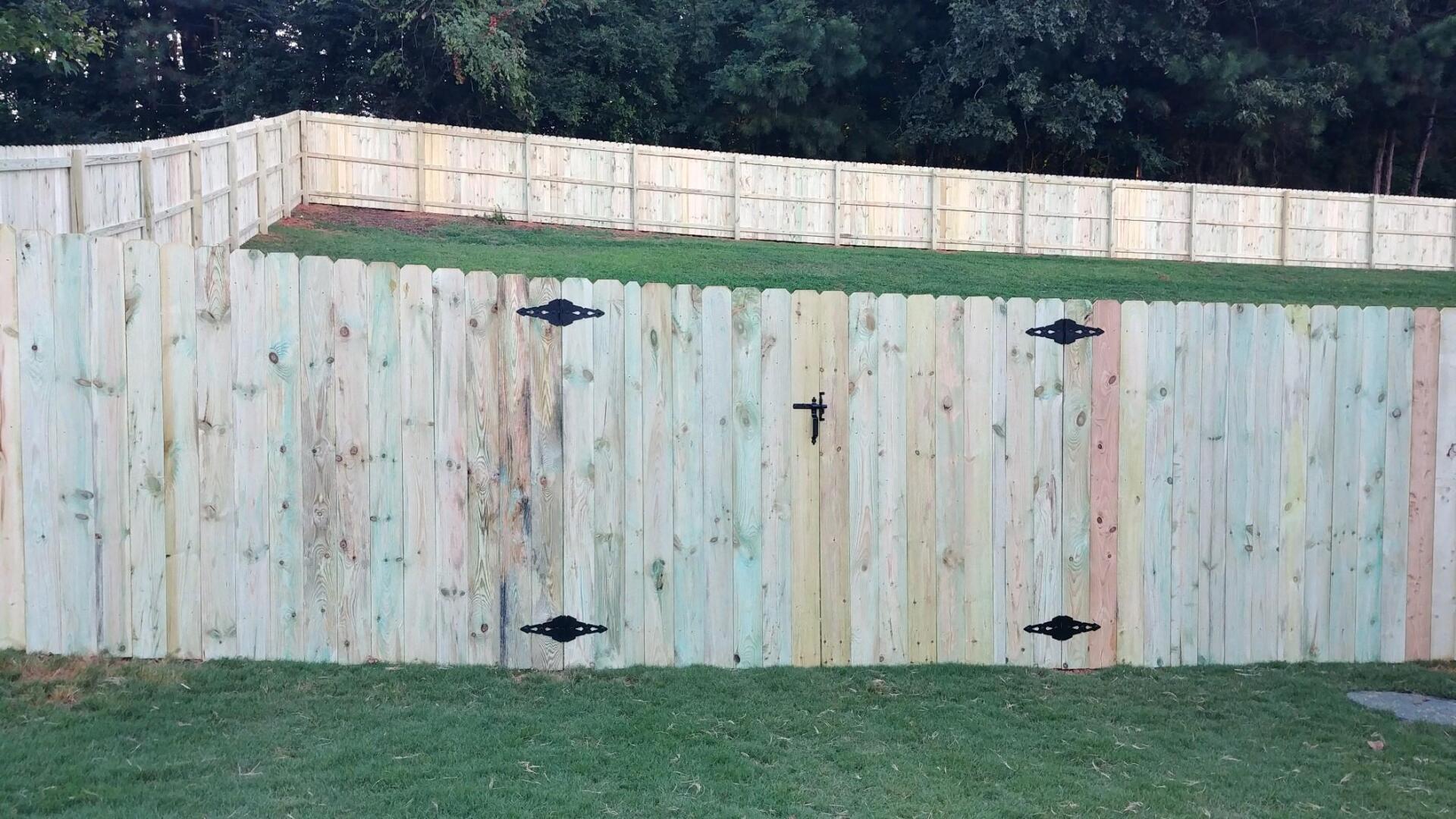 A wooden fence is sitting on top of a lush green lawn.