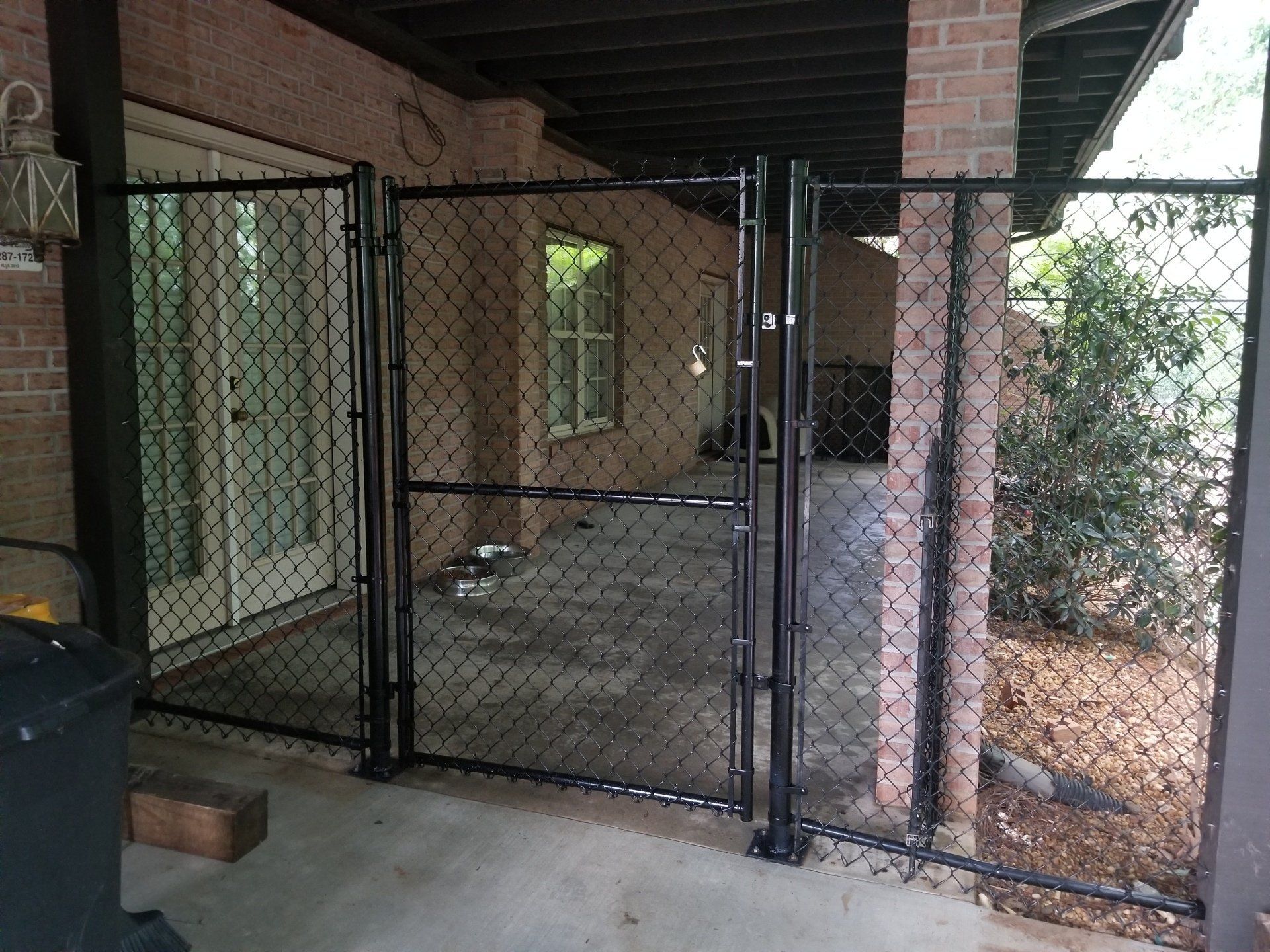 A black chain link fence is surrounding a patio area.