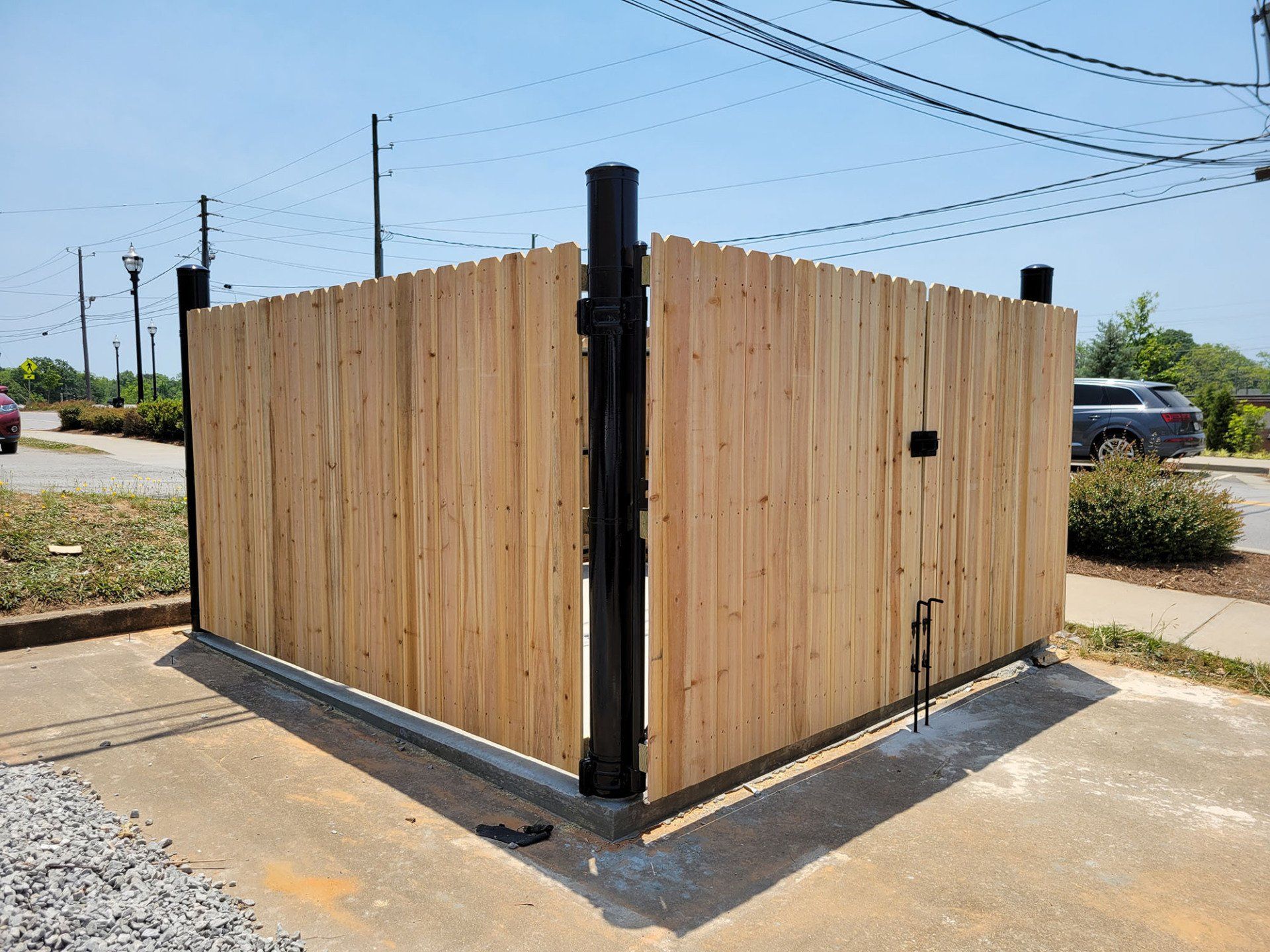 A wooden fence is sitting in the middle of a parking lot.