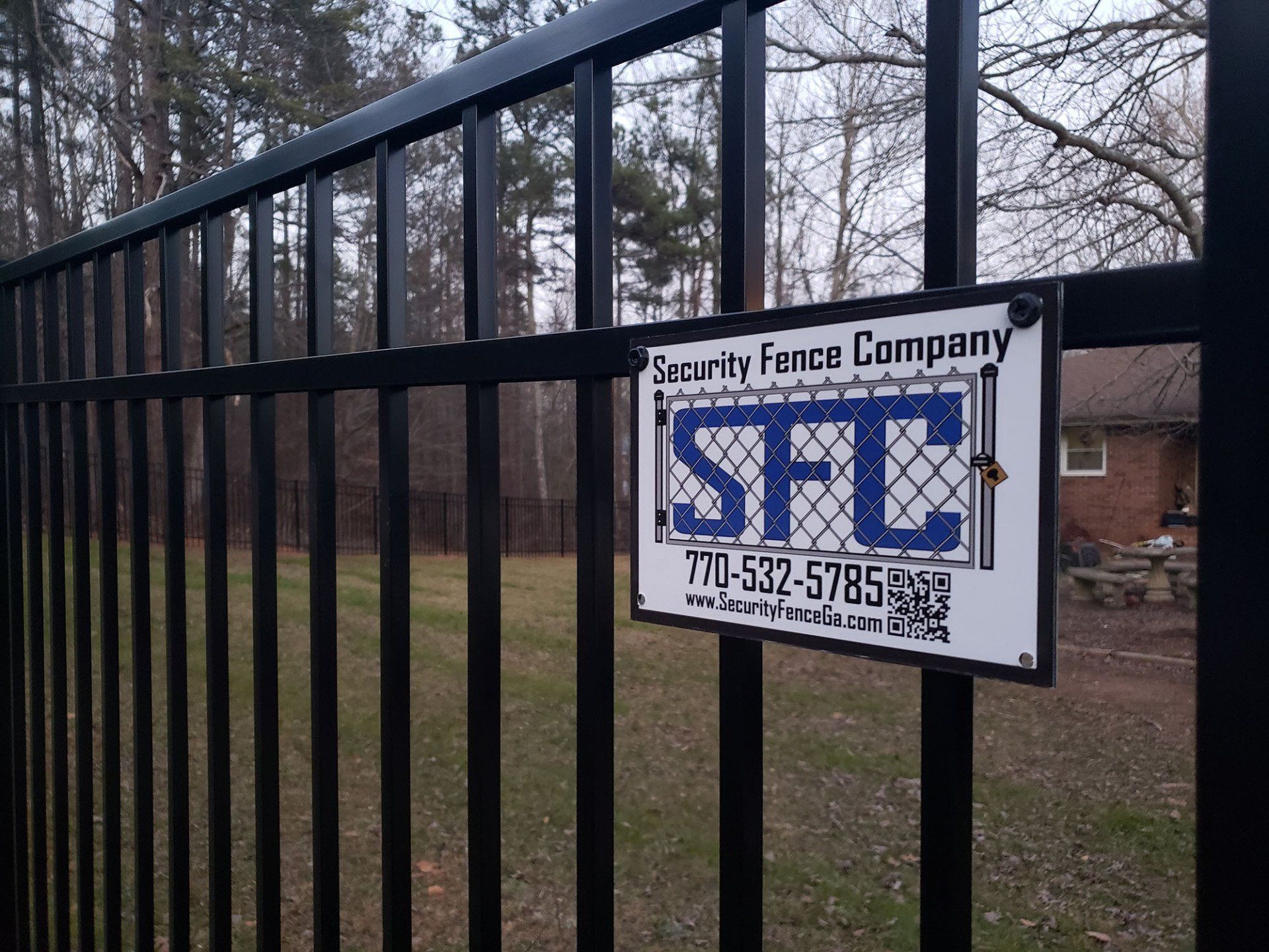 A black fence with a sign that says security fence company