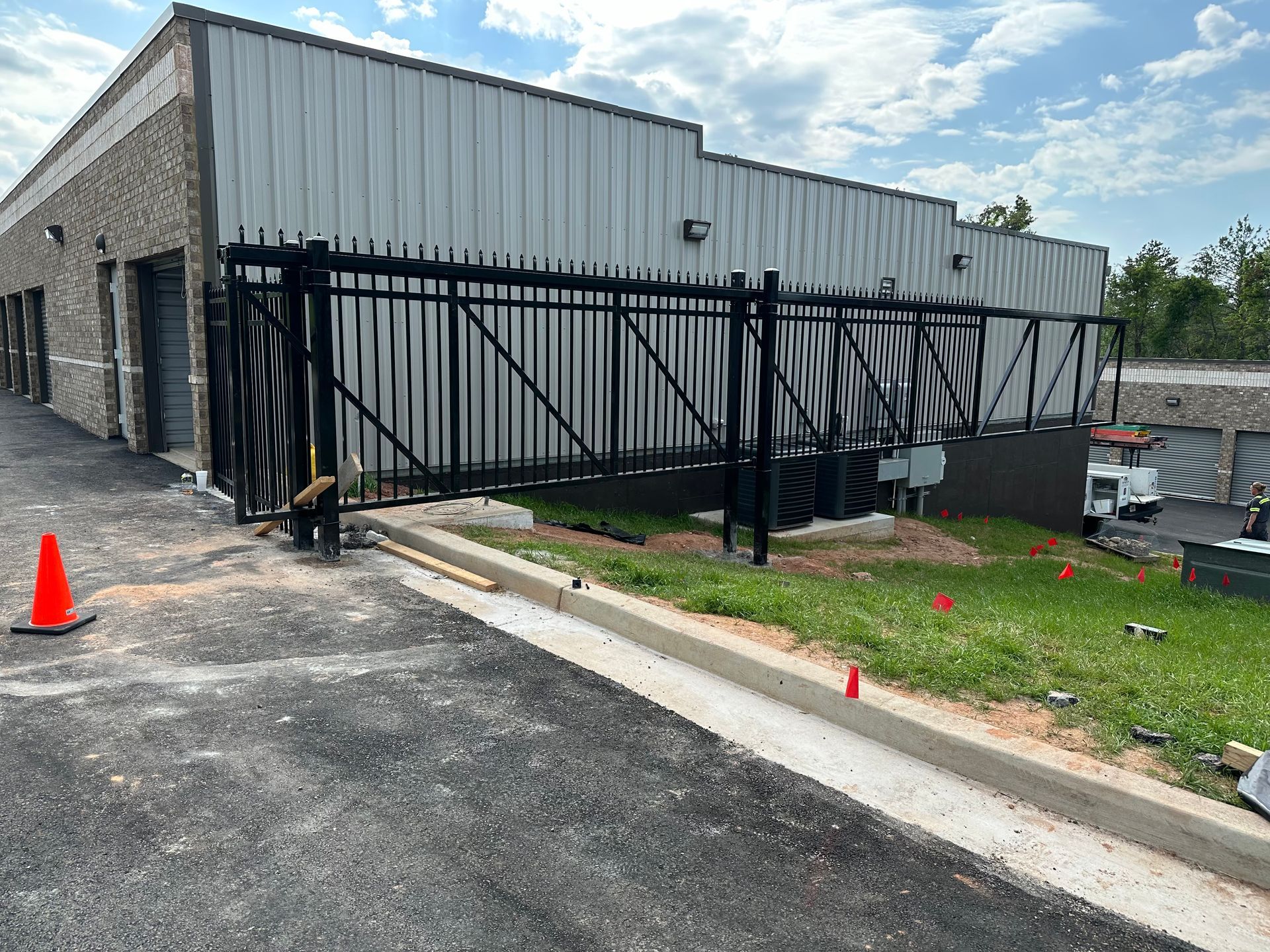 A sliding gate is being installed in front of a building.