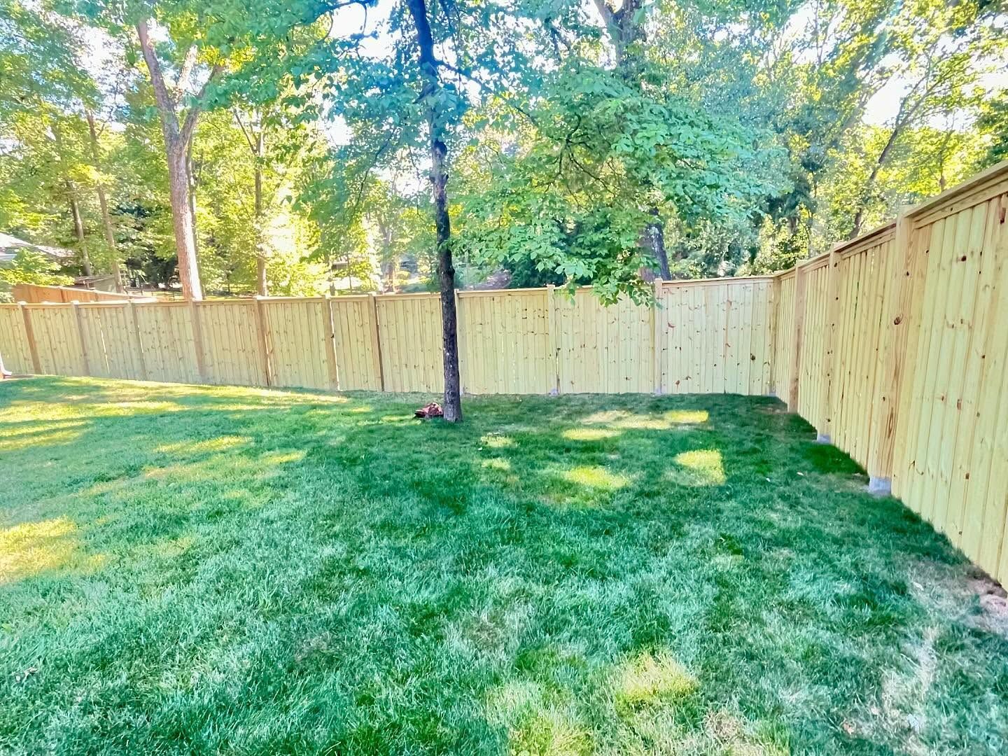 A wooden fence is sitting on top of a lush green hillside.