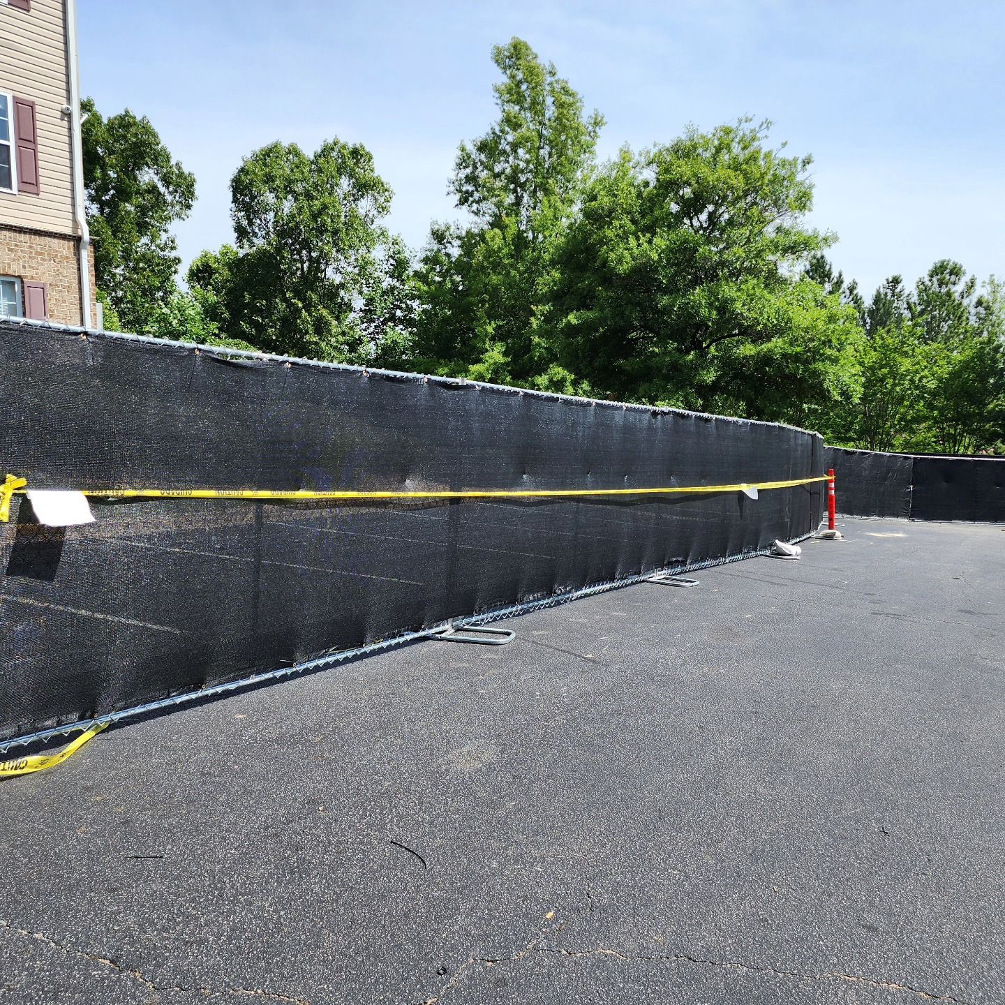 A large black fence with a yellow tape around it