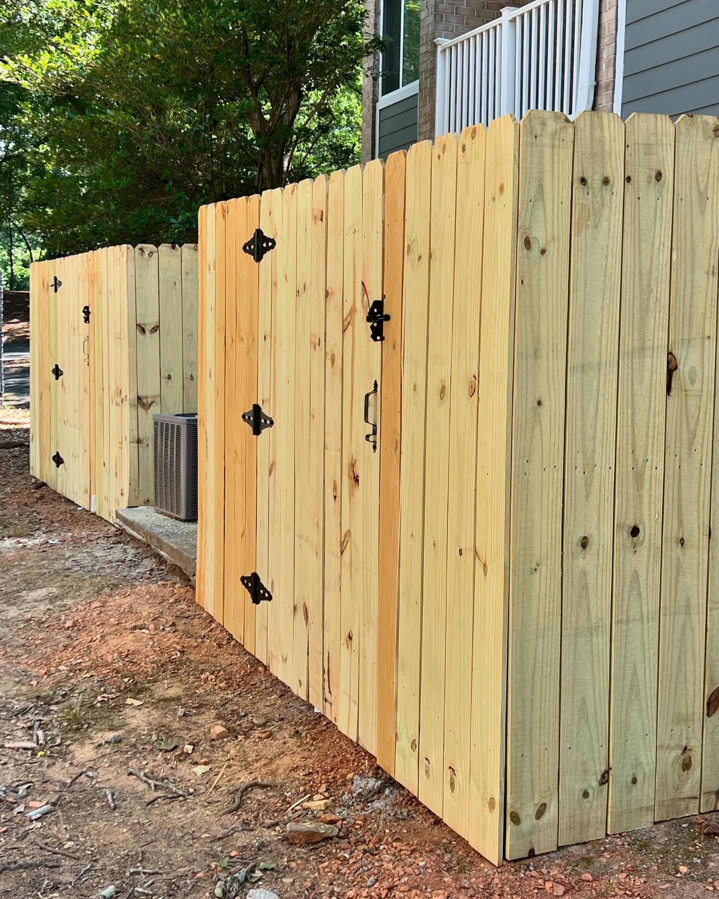 A wooden fence is being built in front of a house.