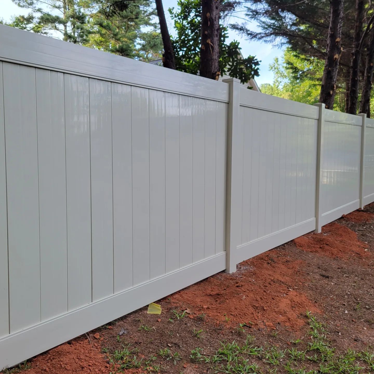 A white fence with trees in the background