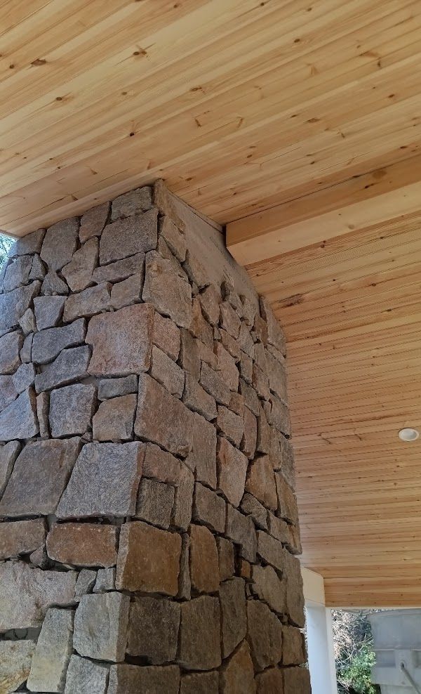 A stone chimney with a wooden ceiling above it