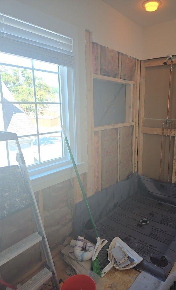 A room with a window and a mop on the floor