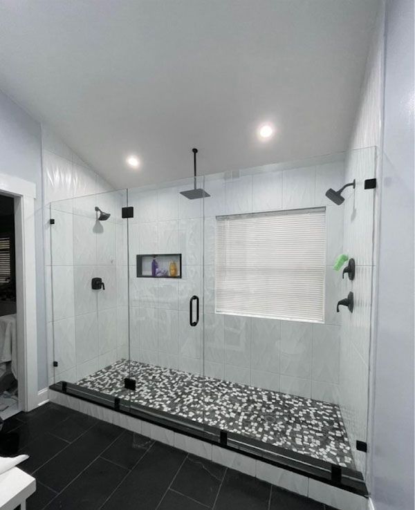 A bathroom with a walk in shower and a window