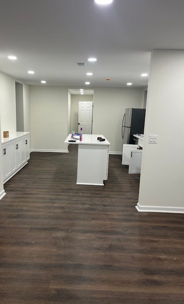 A large empty room with hardwood floors and white walls