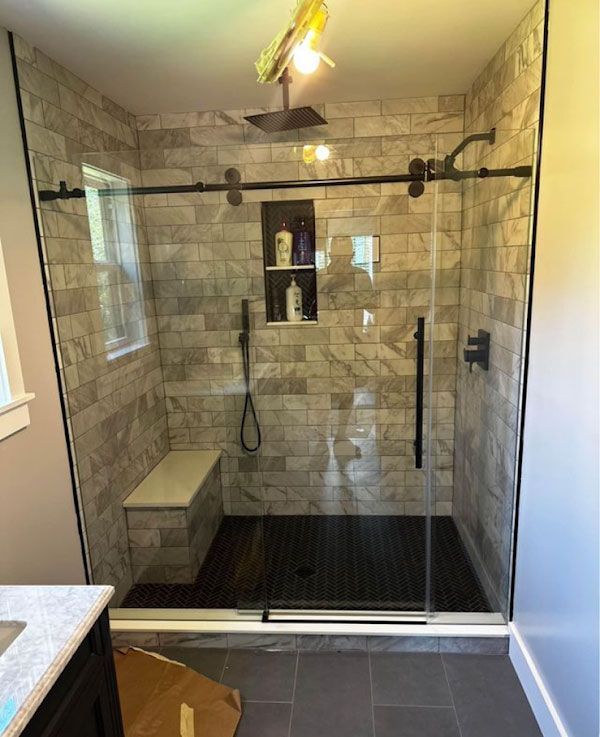 A bathroom with a sliding glass shower door