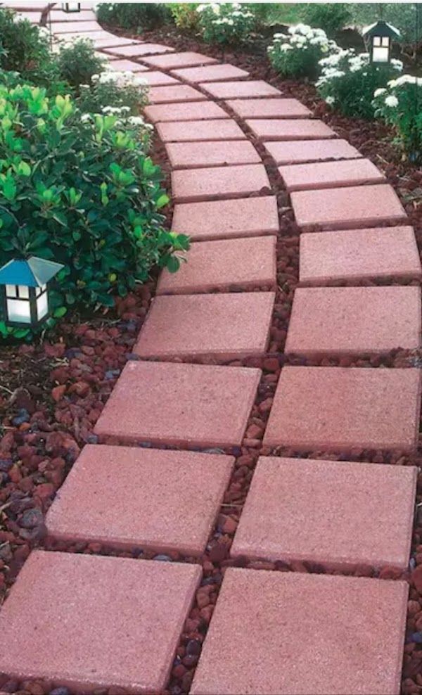 A walkway made of red tiles in a garden
